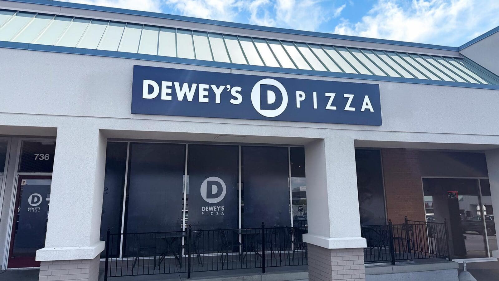Exterior storefront of Dewey's Pizza in Creve Coeur with branded signage above large front windows.